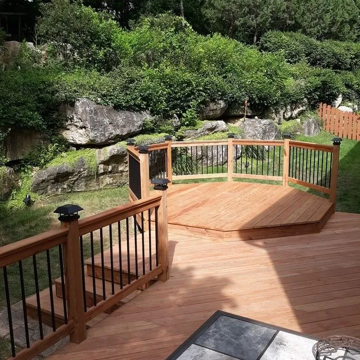 Restored multi-level wood deck with railings and landscape lighting in St. Louis