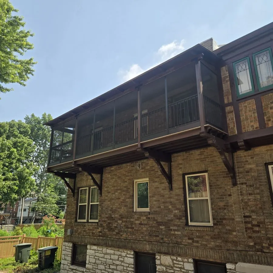 Elevated screened-in porch on a Tudor brick home