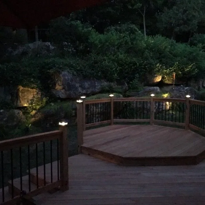 Deck with post-cap and landscape lighting at night