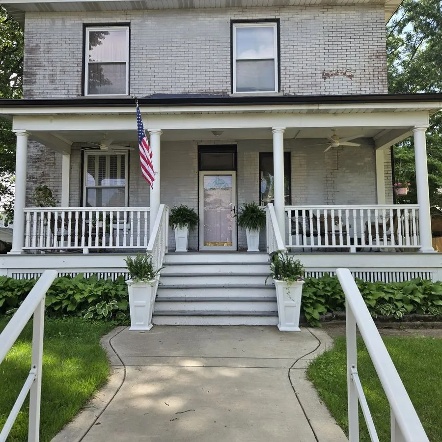 Restored historic front porch with columns and railings on a St. Louis home